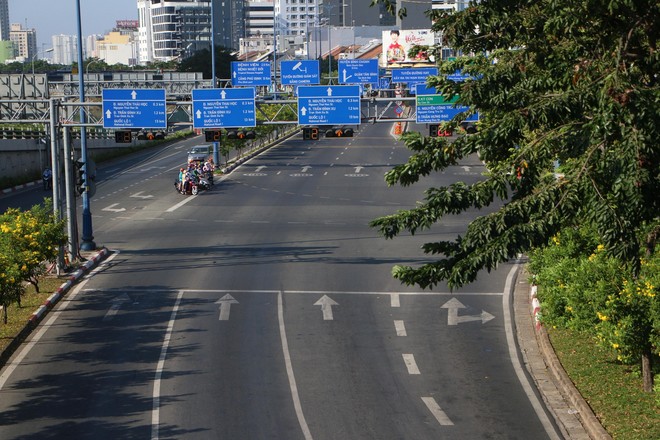 Đường phố TPHCM yên ả, rợp bóng cờ hoa trong ngày mùng 1 Tết - Ảnh 1.