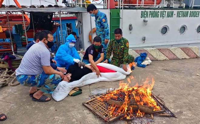 Các chiến sỹ Hải đội 2 (Bộ đội biên phòng) sơ cứu, đốt lửa sưởi ấm cho nạn nhân.