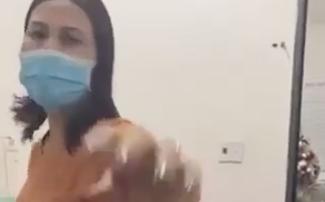 Nữ nhân viên y tế Hải dùng tay giật điện thoại của người dân đang quay mình.