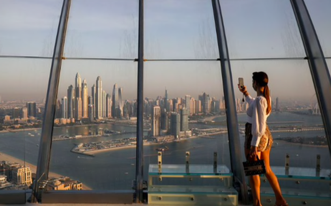 Một phụ nữ đang chụp ảnh "tự sướng" từ một toà tháp ở Dubai. Ảnh: Reuters.