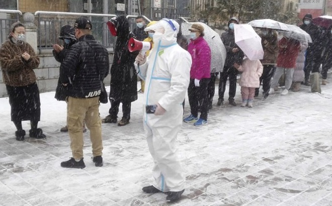 Người dân xếp hàng dưới tuyết chờ đến lượt xét nghiệm tại thành phố Trường Xuân, tỉnh Cát Lâm. Ảnh: AP