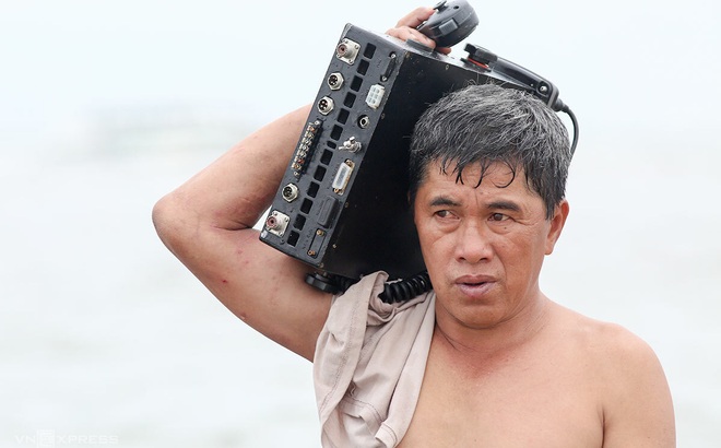 Thuyền trưởng Lê Sen tháo thiết bị vô tuyến từ chiếc ca nô bị nạn (Ảnh: T.X)