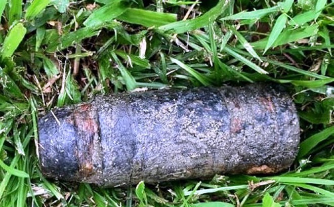 Đầu đạn pháo 100mm được phát hiện trên bãi cỏ ven sông Hương. Ảnh: CTV