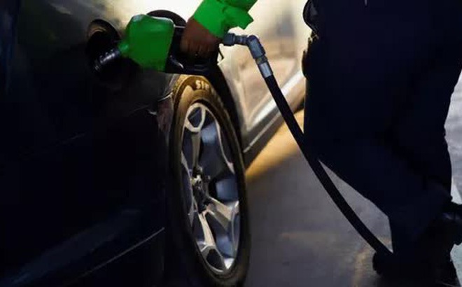 Một nhân viên cửa hàng xăng dầu ở Ciudad Juarez, Mexico đổ xăng cho một công dân Texas sau khi giá xăng dầu tại Mỹ tăng mạnh - Ảnh: Reuters