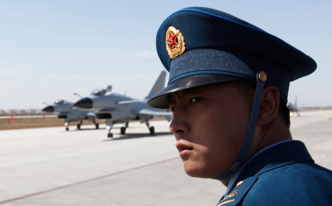 Một sĩ quan Không quân Trung Quốc đứng gần các máy bay chiến đấu J-10 chờ cất cánh (Ảnh: Reuters)