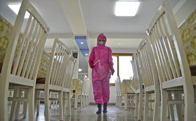 Một nhân viên phun khử trùng nhà ăn tại một nhà máy ở Bình Nhưỡng (Triều Tiên). Ảnh: Reuters