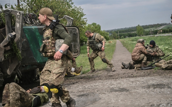 Binh sĩ Ukraine hỗ trợ đồng đội trên tiền tuyến tại Donbass ngày 21/5. Ảnh: AFP