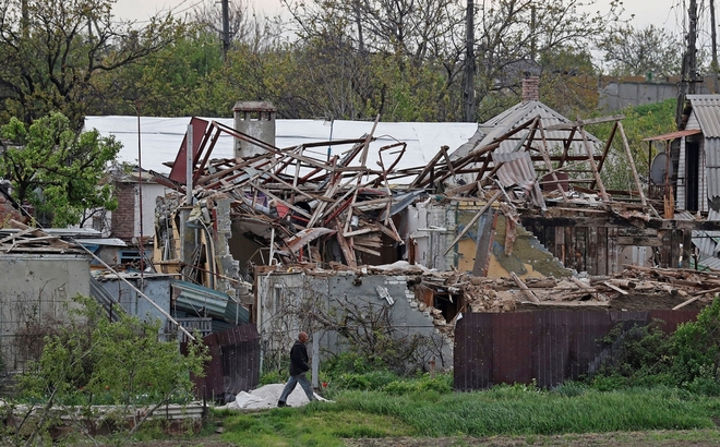 Một người dân địa phương đi ngang qua những ngôi nhà bị phá hủy ở Mariupol, Ukraine, vào ngày 5/5. Ảnh: Reuters