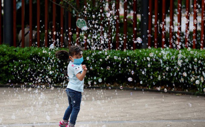 Một số chuyên gia cho rằng trẻ em sau đại dịch dễ bệnh hơn - Trong ảnh: Một em bé đeo khẩu trang khi chơi đùa ở Thượng Hải - Trung Quốc. Ảnh: REUTERS