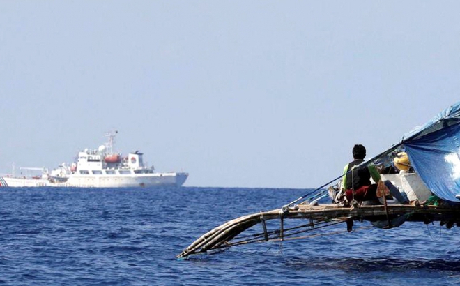 Ngư dân Philippines quan sát tàu Cảnh sát biển Trung Quốc tuần tra gần bãi cạn Scarborough. Ảnh: Reuters