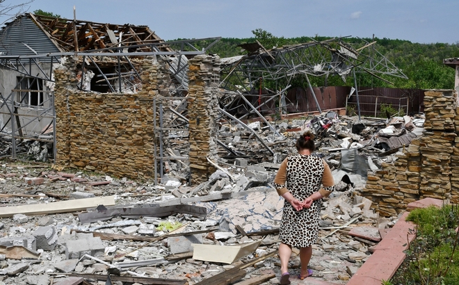 Một người phụ nữ đi qua đống đổ nát tại thành phố Sloviansk, Ukraine. Ảnh: AP.