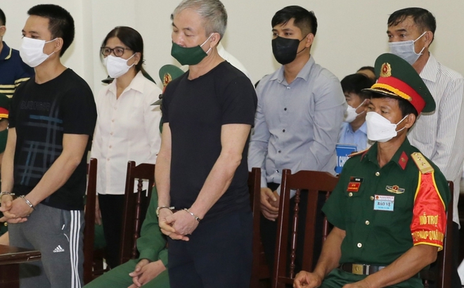Bị cáo Lê Văn Minh (áo đen, tóc bạc) tại phiên tòa.