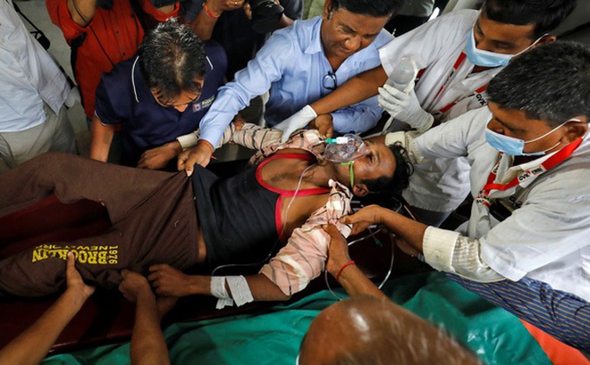 Một người ngộ độc rượu tại quận Ahmedabad được đưa đi cấp cứu hôm 26-7 - Ảnh: REUTERS