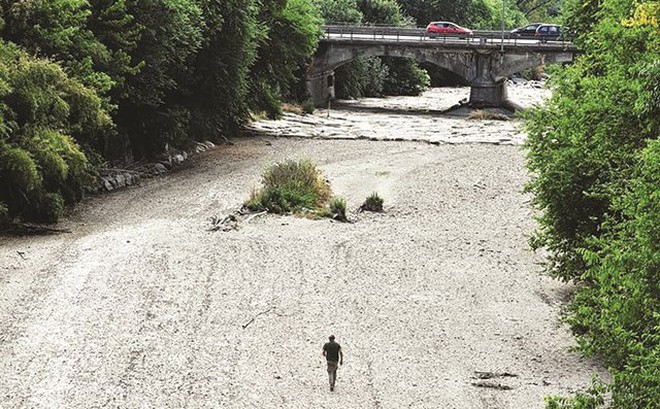 Một người đàn ông đi trên đáy khô cạn của sông Sangone - một nhánh của sông Po. Nguồn: Reuters.