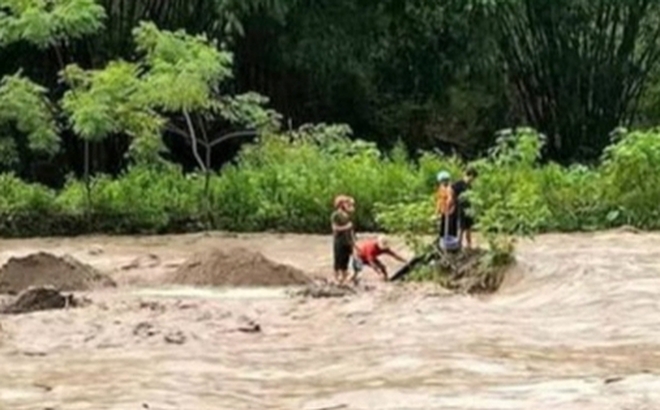 Hình ảnh 4 nạn nhân chơi vơi giữ dòng nước lũ trước khi bị lũ dâng cao cuốn trôi - Ảnh: Mạng xã hội