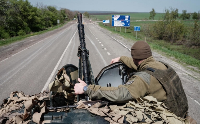 Một binh sĩ Ukraine ngồi trên chiếc xe bọc thép trên con đường gần Sloviansk, miền Đông Ukraine, vào ngày 26/4/2022. Ảnh: AFP