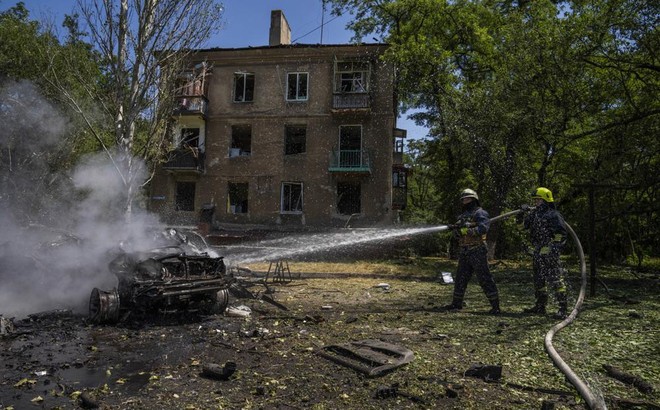 Lính cứu hỏa xịt nước vào chiếc xe đang bốc cháy ở Kramatorsk, vùng Donetsk, miền đông Ukraine, ngày 7/7/2022. Ảnh AP