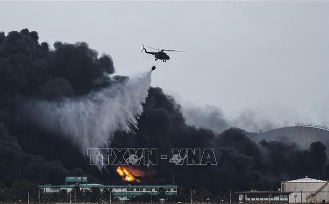 Trực thăng phun nước dập lửa tại hiện trường vụ cháy kho chứa nhiên liệu ở Matanzas, Cuba ngày 8/8/2022. Ảnh: AFP/TTXVN