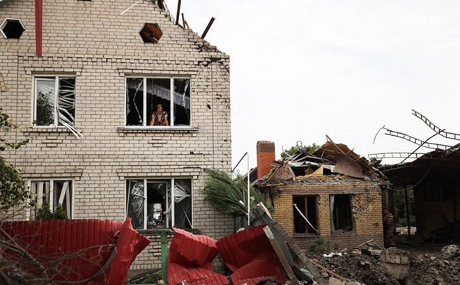 Cư dân Iryna, 74 tuổi, nhìn ngôi nhà bị hư hại sau cuộc không kích tại thành phố Kramatorsk ở vùng Donetsk phía đông Ukraine ngày 12-8 - Ảnh: REUTERS