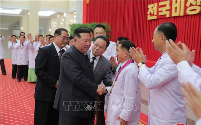 Nhà lãnh đạo Triều Tiên Kim Jong-un (trái) gặp gỡ các nhân viên y tế, các nhà khoa học tham gia chống dịch COVID-19 tại buổi lễ ở Bình Nhưỡng, ngày 11/8/2022. Ảnh: YONHAP/TTXVN