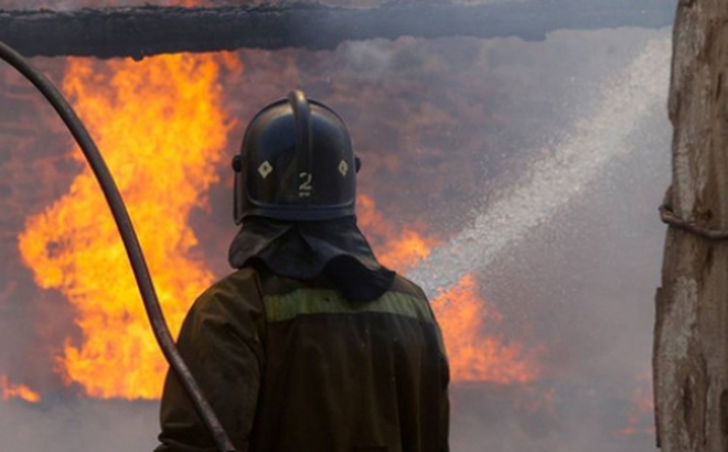 Một nhân viên cứu hỏa đang nỗ lực dập tắt đám cháy tại Crimea ngày 16/8. Ảnh: TASS