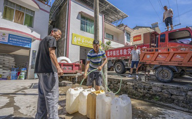 Người dân lấy nước tại một địa điểm phân phối nước ở huyện Vu Sơn, thành phố Trùng Khánh, tây nam Trung Quốc hôm 13-8 - Ảnh: TÂN HOA XÃ