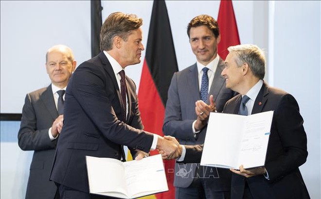 Thủ tướng Đức Olaf Scholz (trái) và Thủ tướng Canada Justin Trudeau (thứ 2, phải) chứng kiến lễ ký thỏa thuận hợp tác xuất khẩu nhiên liệu hydro sang châu Âu giữa Giám đốc điều hành Volkswagen AG (thứ 2, trái) và Bộ trưởng Sáng kiến khoa học-công nghệ Canada Francois-Philippe Champagne (phải) tại Toronto (Canada) ngày 23/8/2022. Ảnh: AFP/TTXVN