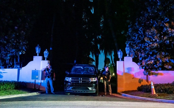 Đặc vụ FBI cầm súng trường đứng bên cạnh ô tô, gác ở lối vào dinh thự Mar-a-Lago. Ảnh: NYT