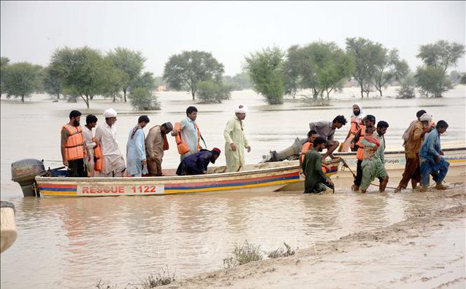 Người dân sơ tán khỏi khu vực ngập lụt ở tỉnh Punjab, Pakistan ngày 27/8/2022. Ảnh: THX/TTXVN