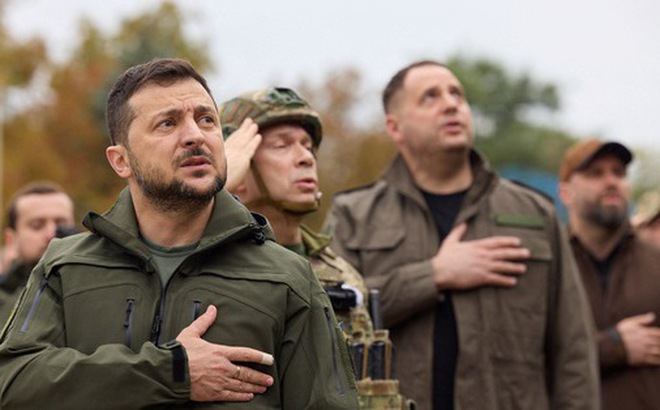 Tổng thống Ukraine Zelensky hát quốc ca trong lễ thượng cờ ở thị trấn Izium vừa được lực lượng vũ trang Ukraine tái chiếm ngày 14-9 - Ảnh: REUTERS