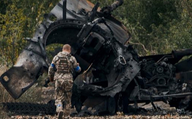 Một người lính Ukraine gần xe tăng Nga bị phá hủy ở khu vực Kharkov vào ngày 11/9/2022. Ảnh: AP