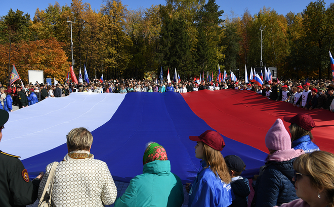 Mọi người cầm lá cờ Nga khổng lồ ủng hộ cuộc trưng cầu dân ý về việc gia nhập Nga của Cộng hòa Nhân dân Donetsk và Lugansk (DPR, LPR), cũng như các phần do Nga kiểm soát ở khu vực Zaporozhye và khu vực Kherson của Ukraine