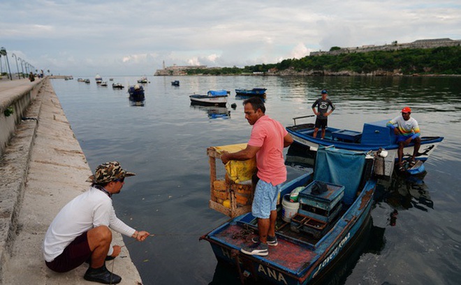 Người dân Cuba đưa tàu thuyền về nơi neo đậu ở Havana trong ngày 26-9, ứng phó với bão Ian - Ảnh: REUTERS
