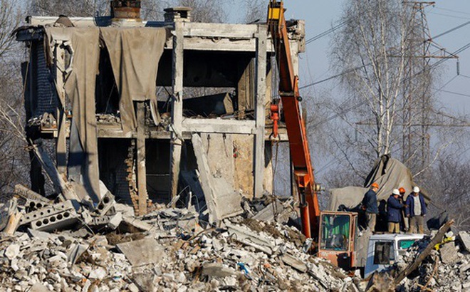 Các công nhân thu dọn đống đổ nát của một tòa nhà bị phá hủy sau vụ không kích của Ukraine. Ảnh: Reuters