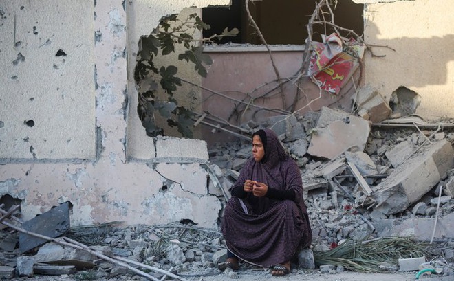 Một người dân Palestine ngồi trước ngôi nhà của họ bị phá hủy trong các cuộc không kích của Israel ở phía nam Dải Gaza ngày 17/10/2023