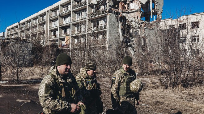 Binh sĩ Ukraine đi qua một tòa nhà bị phá hủy ở Maryinka, tỉnh Donetsk.