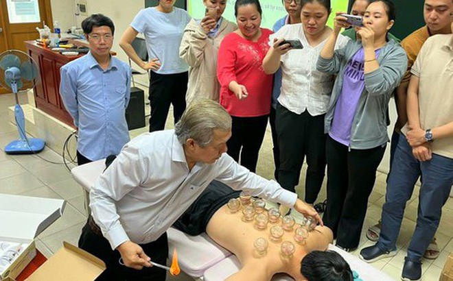 Bác sĩ chuyên khoa II Huỳnh Tấn Vũ hướng dẫn học viên thực hiện phương pháp giác hơi trị bệnh Ảnh: HẢI YẾN