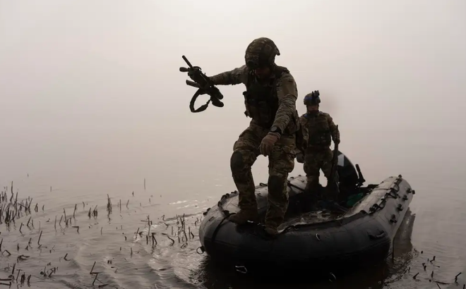 Một quân nhân Ukraine nhảy khỏi thuyền để di chuyển tới bờ sông Dnipro gần Kherson, Ukraine, vào tháng 10/2023. Ảnh:AP