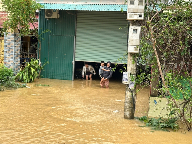 Nước lũ vây tứ phía, người dân Quảng Bình đứng trên nóc nhà nhận hàng cứu trợ - Ảnh 9.