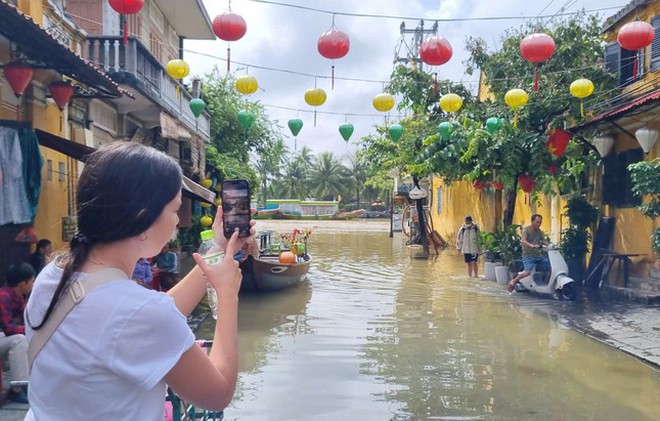 Nước lụt tràn vào phố cổ Hội An, khách Tây lội bì bõm chụp hình - Ảnh 6.