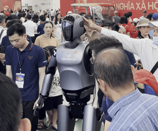 Khoảnh khắc một người đi theo xoa đầu robot hình người VinRobotics tại Triển lãm 80 năm Hành trình Độc lập - Tự do - Hạnh phúc diễn ra ở Trung tâm Triển lãm Quốc gia (Đông Anh, Hà Nội). Ảnh: PNS