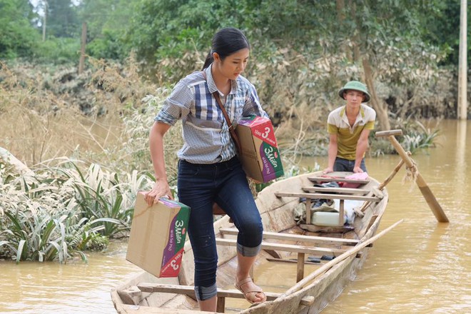 Hoa hậu Ngọc Hân bì bõm lội nước, ôm đồ cứu trợ ở miền Trung - Ảnh 1.