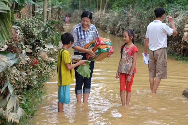 Hoa hậu Ngọc Hân bì bõm lội nước, ôm đồ cứu trợ ở miền Trung - Ảnh 2.