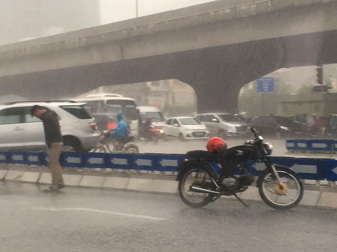 Chàng trai dừng xe, đứng dầm mưa giữa đường Khuất Duy Tiến - Ảnh 1.