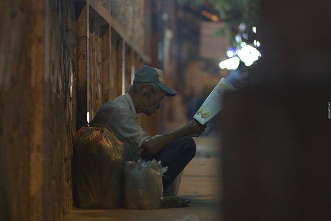 Có một cụ ông nhặt ve chai say sưa đọc báo dưới ánh đèn trên phố Sài Gòn - Ảnh 3.