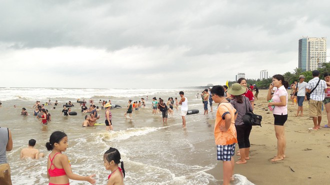 [Ảnh] Mặc bão vào, hàng trăm du khách liều mình tắm biển rồi bỏ chạy khi có sóng lớn - Ảnh 4.