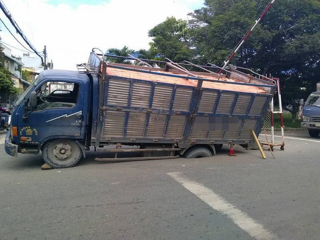 Tình cảnh hy hữu: Ô tô đỗ trên đường nhựa bị lún bánh  - Ảnh 1.