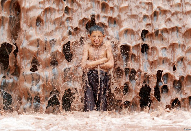 24h qua ảnh: Cậu bé tắm mát dưới thác nước ô nhiễm - Ảnh 5.