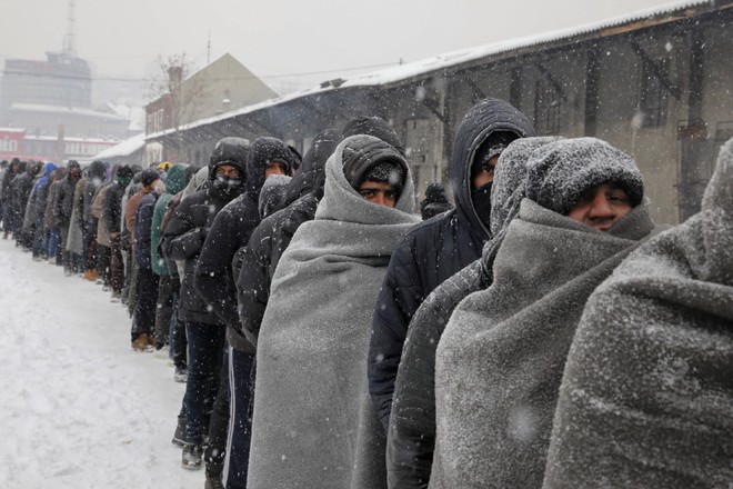 24h qua ảnh: Hàng dài người di cư chờ nhận đồ ăn trong mưa tuyết - Ảnh 10.
