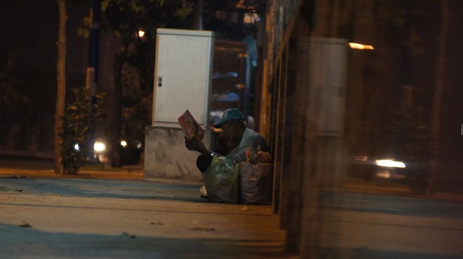 Có một cụ ông nhặt ve chai say sưa đọc báo dưới ánh đèn trên phố Sài Gòn - Ảnh 2.